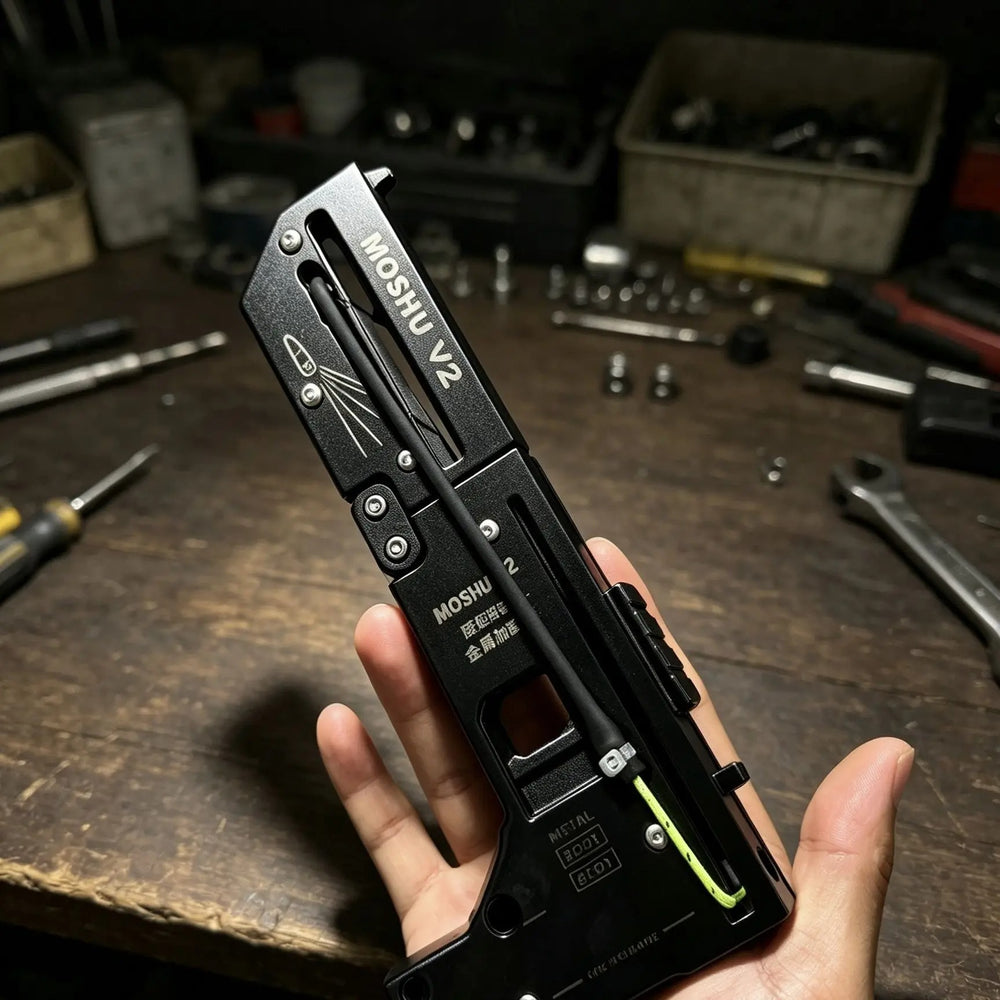 Top edge of the MOSHU V2 folding slingshot showing the machined metal frame
