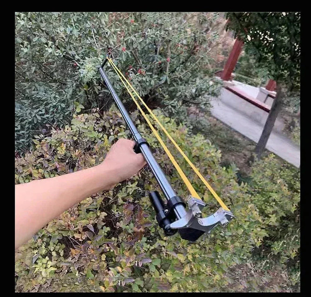 Shooter aiming the telescopic slingshot rifle with laser sight at an outdoor target